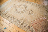 Distressed Oushak rug with antique ivory, coffee brown meandering vine border and wear.