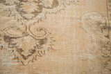 Distressed Oushak carpet texture: worn ivory pile, coffee brown motifs, exposed foundation.