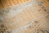 Muted antique ivory and coffee brown tones on the distressed Oushak rug surface.