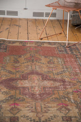 Distressed Oushak rug section: faded blush, gold geometric motifs, soft even wear, side selvage.