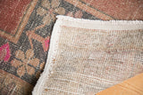 Vintage Oushak rug's hand-knotted foundation with original selvages and distressed pile.