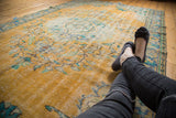 Distressed vintage Oushak rug with an even wear, showcasing bright gold and faded floral designs.