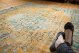 Distressed Oushak rug in bright gold, royal blue, mint green floral medallion motif.
