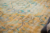 Distressed vintage Oushak carpet texture with bright gold, royal blue, and mint floral design.