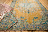 Traditional distressed gold Oushak rug's blue and mint green border patterns, with even wear.