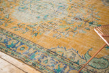 Distressed vintage Oushak rug, showing gold, brilliant royal blue, and mint green border.