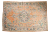Vintage distressed Oushak rug with center medallion, faded peach, blue, mint patterns.