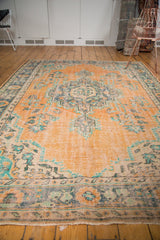 Distressed Turkish Oushak rug detail: faded peach, royal blue, mint green floral patterns, even wear.