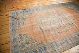 Faded royal blue and pistachio green floral border detail on a distressed vintage Oushak rug.
