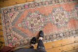 Decorative stepped corner spandrel in apricot, pink, and silver on vintage Oushak runner.