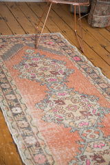 Textured distressed Oushak runner, featuring an apricot field with even wear and pink motifs.