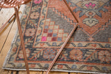 Distressed vintage Oushak runner with dusty apricot, platinum, and bright pink geometric motifs.