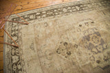 Distressed vintage Oushak carpet section featuring low pile with time-softened beige and charcoal patterns.