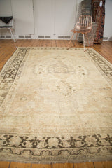 Distressed vintage Oushak rug end, showing faded charcoal border and exposed foundation.