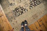 Distressed vintage Oushak rug with prominent abrashes, patterns in antique ivory and charcoal black.