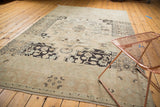 Angled view of a distressed vintage Oushak carpet, with soft abrashes and muted colors.