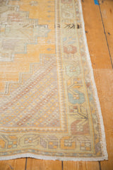 Detail of distressed Oushak runner corner with geometric border in soft gold and muted tones.