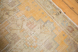 Distressed saffron gold yellow and beige Oushak rug pile with serrated geometric spandrel details.