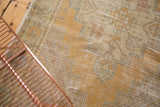 Distressed saffron gold Oushak rug runner close-up, showing geometric patterns and even wear.