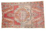 Distressed vintage Oushak rug: roundel medallion, abrash, red, beige, and gold rococo stylization. 4'6