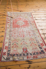 Distressed Oushak runner's end section, featuring Makri plant motifs, faded red and ivory hues.