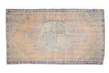 Vintage Distressed Oushak rug with peach field, roundel medallion, faded blue vinery, even wear.