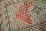 Distressed Oushak rug, detail of brick red abrash field, beige mini boteh, and quatrefoil medallion.