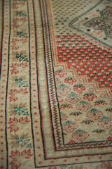 Distressed Oushak rug detail: abrash, brick red field, mint green motifs, patterned ivory border.