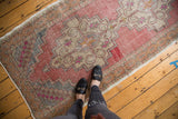Distressed Oushak rug runner showcasing blush and beige stepped diamond medallion with even wear.