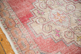 Faded blush and beige rectilinear patterns with fuchsia accents on this distressed Oushak runner.