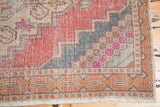 Softly worn hand-knotted Oushak runner detail, with stepped design in blush, charcoal, and fuchsia.