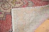 Hand knotted back, fringe, and distressed blush pile of a vintage Oushak rug runner.
