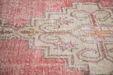 Distressed blush and beige hand-knotted Oushak rug pile with stepped geometric patterns.