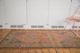 Rectilinear mapping on a distressed Oushak rug in apricot, oxidized silver, and saffron.