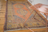 Stepped diamond motifs in apricot, saffron, and silver on a distressed Oushak rug.