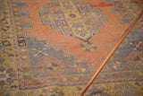 Close-up of vintage distressed Oushak rug's stepped diamond pattern in muted terra cotta.