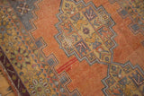 Distressed Oushak rug close-up revealing worn texture and rectilinear patterns in apricot and oxidized silver.