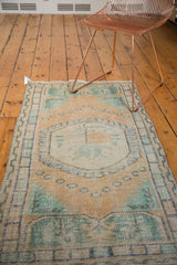Distressed vintage Oushak rug showing peach, mint, roundel, pearl motifs, and light foundation.