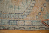 Distressed vintage Oushak rug runner's edge, showing textured pile with peach, mint, and ivory wear.