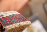 Stack of Bijar CoasterRugs, deep red field with blue and green pattern, natural fringe.