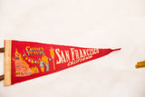 Red felt San Francisco Chinatown flag with architectural graphic, people, and lanterns.