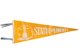 Vintage golden yellow felt pennant featuring a white Statue of Liberty graphic, 8.5x23 inches.