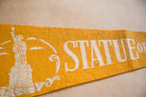 Vintage yellow felt pennant with white Statue of Liberty graphic and text.