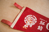 Red felt ties and white edge trim of the souvenir pennant.