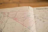 Close-up on the aged paper of the 1930s Hopkins map showing property plots and creases.