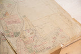 Aged paper and torn corner of the 1930s Hopkins map, revealing street names.
