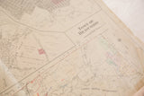 Detail of vintage Hopkins map, showing a torn upper corner and creased aged paper.