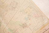 Angled view of a vintage Hopkins map section, showing aged paper and property details.