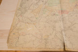 Prominent vertical tear and creased aged paper texture on the vintage Hopkins map.