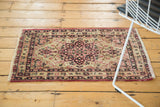 Antique Kerman mat displaying its starburst medallion, vinery, and pale raspberry red accents.